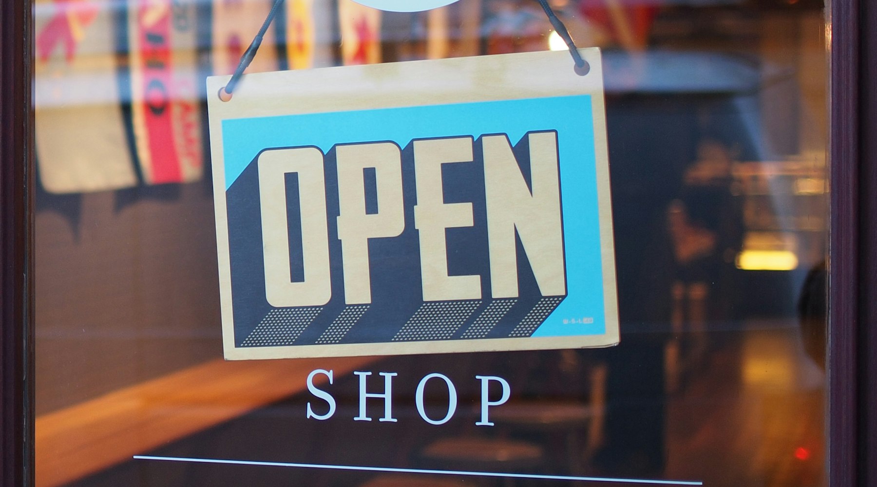 Dükkân kapısında asılı "Open Shop" tabelası